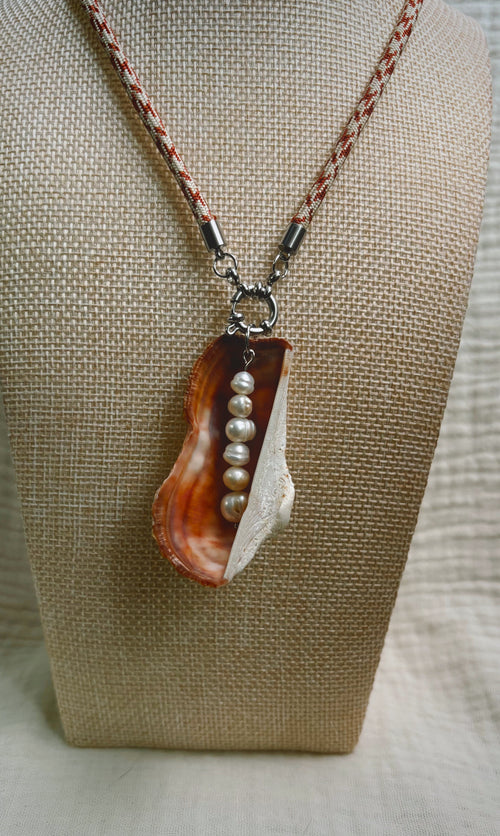 Copper oyster shell with pearls on peach patterned cord