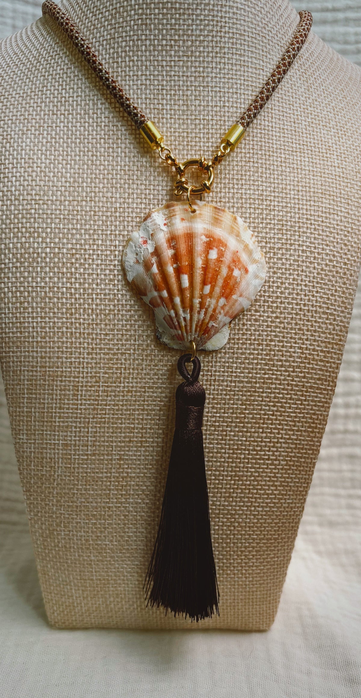 Orange and white scallop shell with black silk tassel