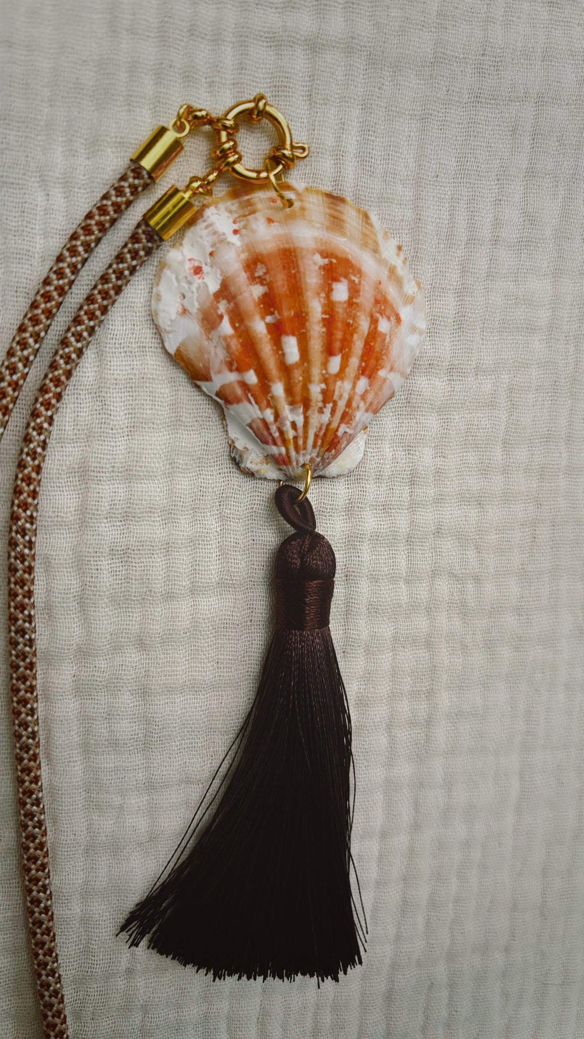 Orange and white scallop shell with black silk tassel