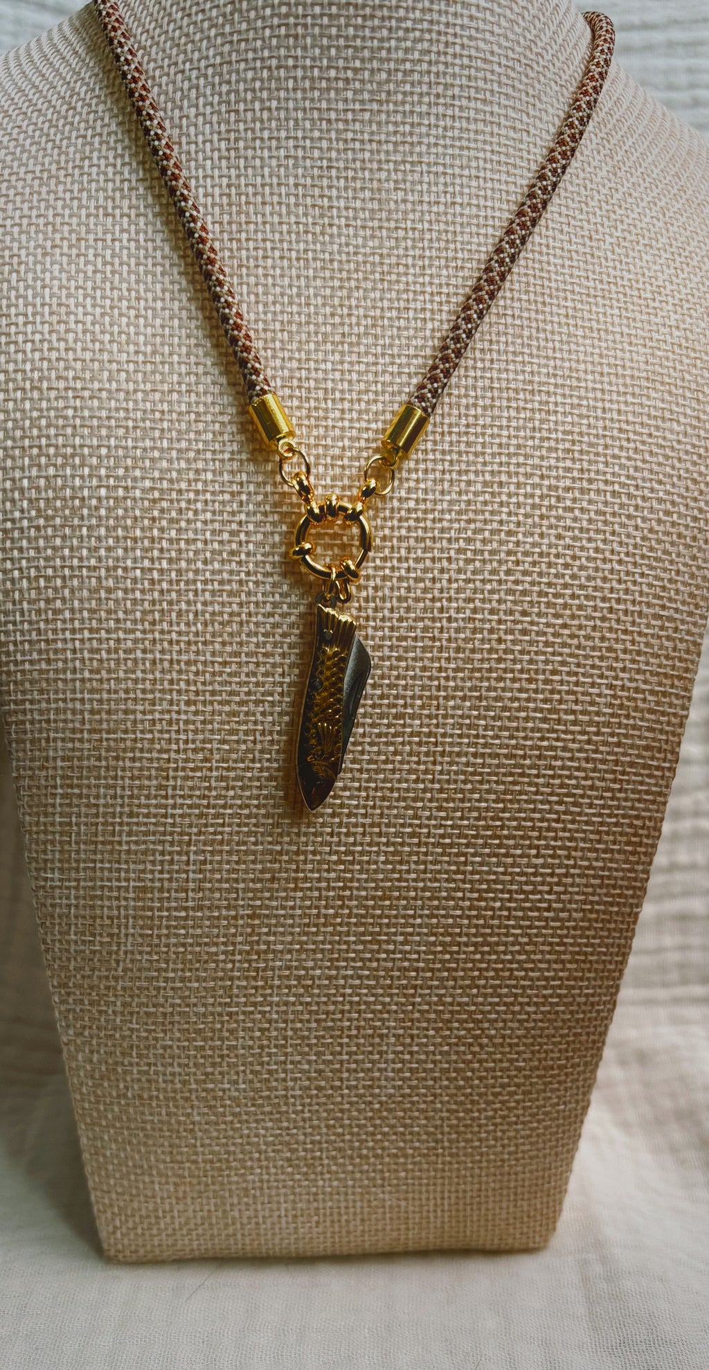 Dark shell fragment pendant on tan spotted paracord