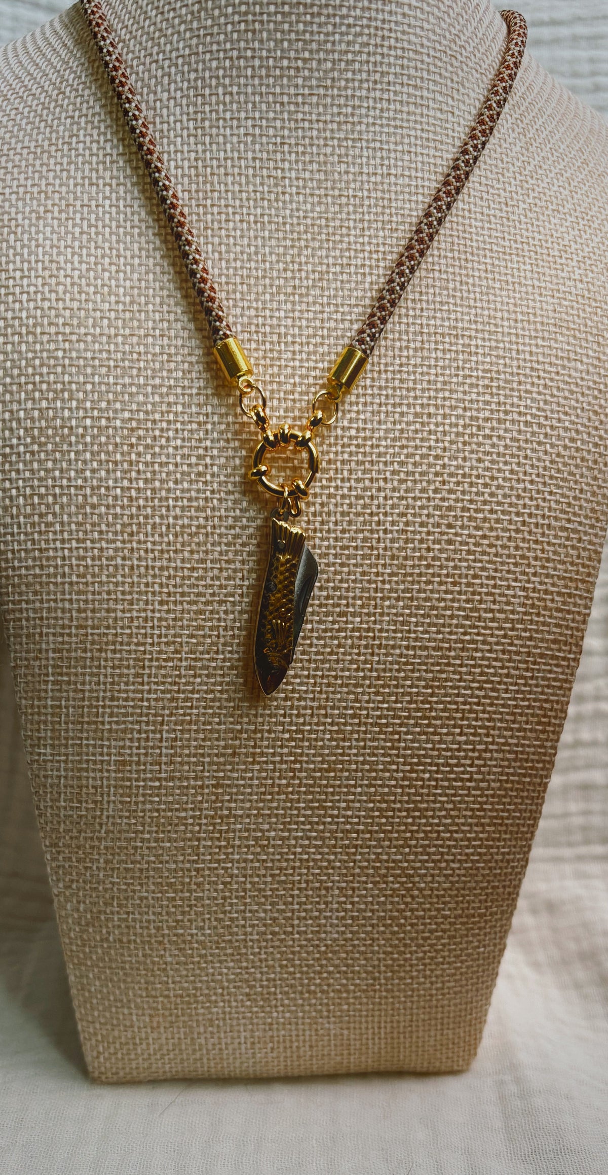 Dark shell fragment pendant on tan spotted paracord